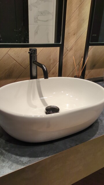 Zdjecie umywalki ceramicznej wygladajacej jak duza biala miska postawiona na stole